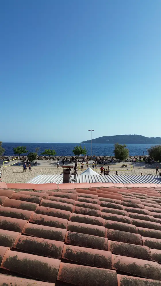 Vue aérienne de la plage du Mourillon à Toulon : les terrains de beach volley et leurs filets, la mer et l'île en arrière-plan