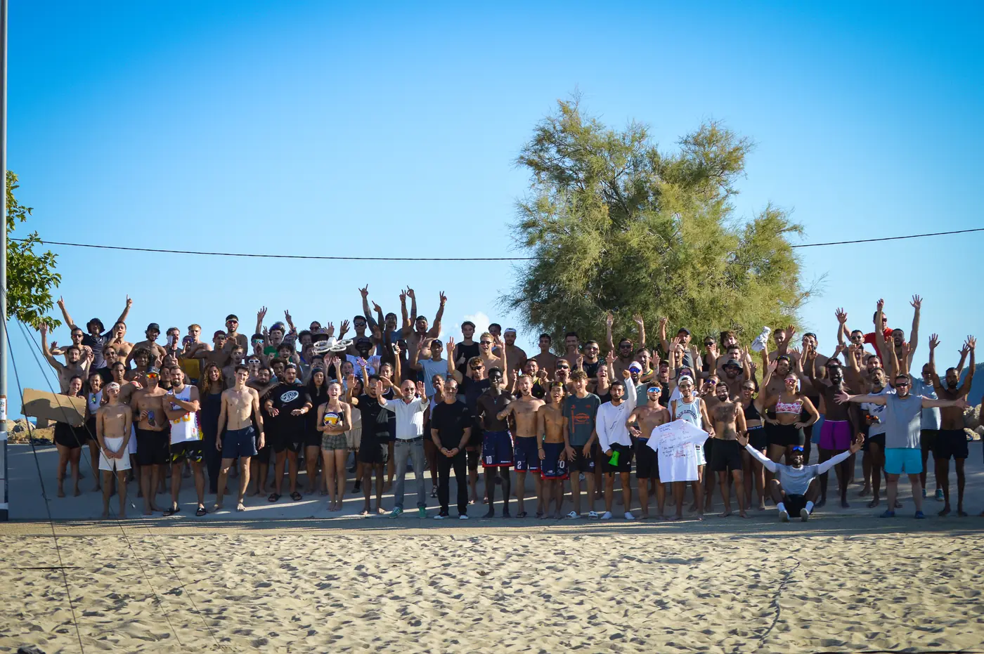 Les participants des tournois de beach volley du Mourillon Volley réunis bras levés sur le terrain de la plage du Mourillon, à Toulon